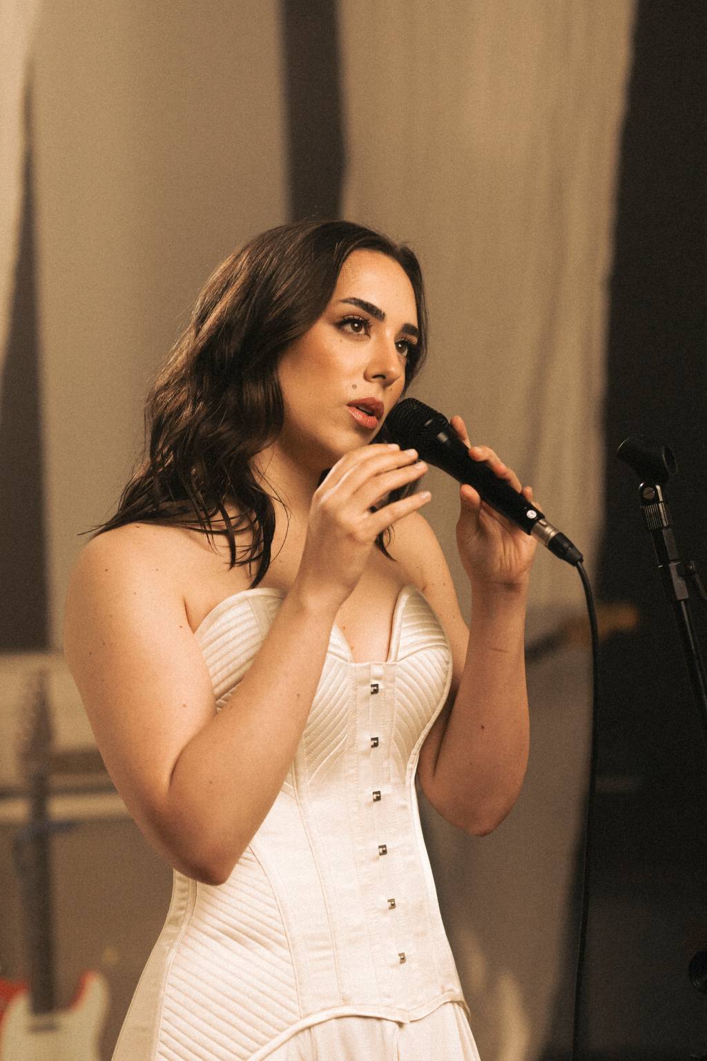 Lara Crédito @kimbrlykoeche-Divulgação (3) A cantora e compositora Lara Silva segurando microfone e vestindo peça branca