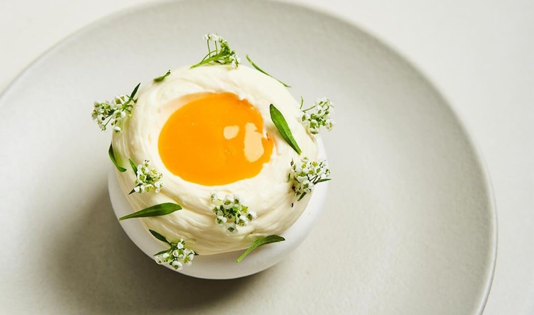 Doce branco com meio amarelo em cima de prato cinza