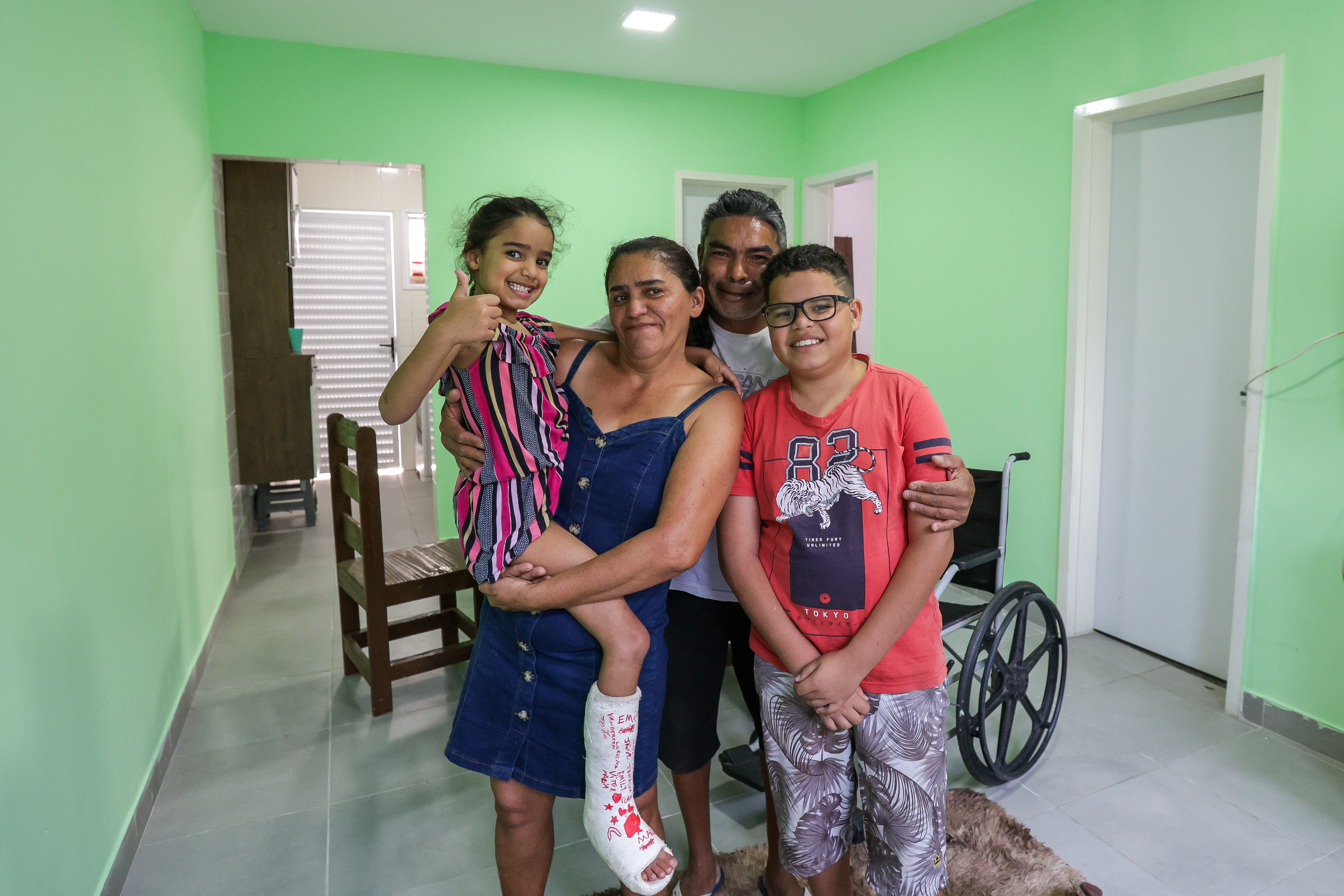 A dona de casa Gracinete dos Santos e sua fam&iacute;lia, e, abaixo, a casa que recebeu ap&oacute;s sair de &aacute;rea de risco