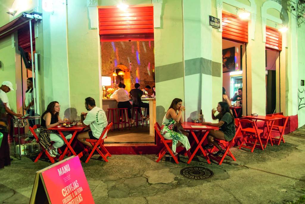 Boteco de Manu Pessoas sentadas em mesa na calçada
