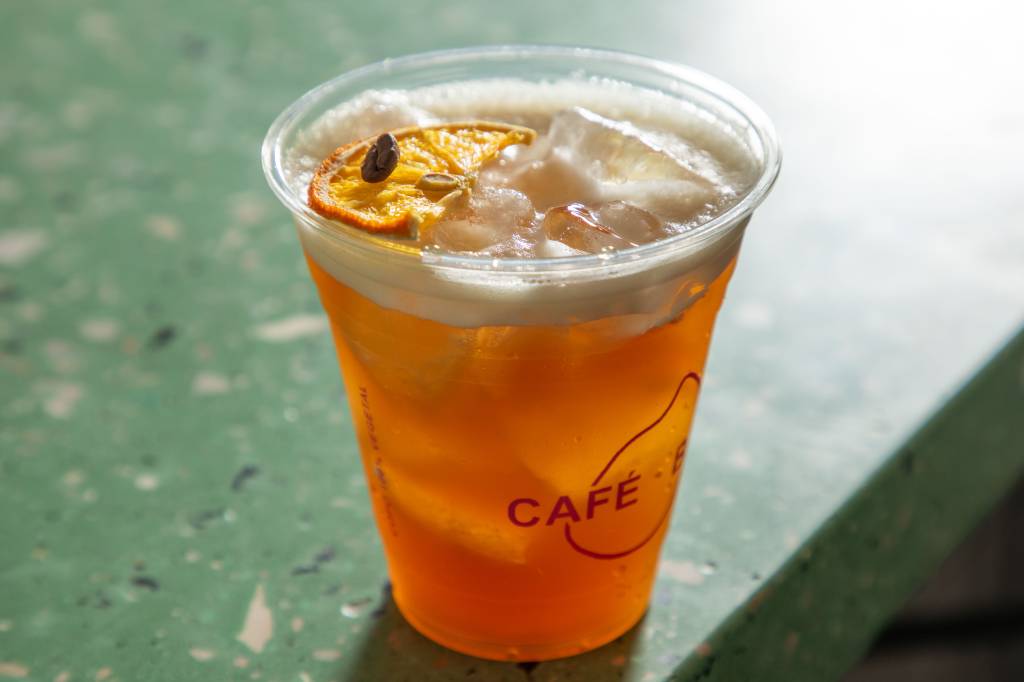 café-coco Tônica _ café + bar Bebida laranja com gelo em cima de balcão