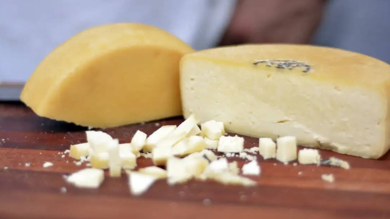 Queijo cortado em tábua de madeira
