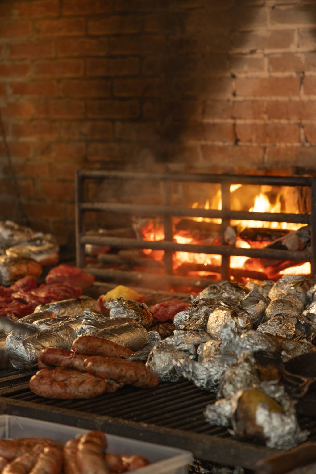 Fuego Celeste Grelha com carnes e fogo atrás