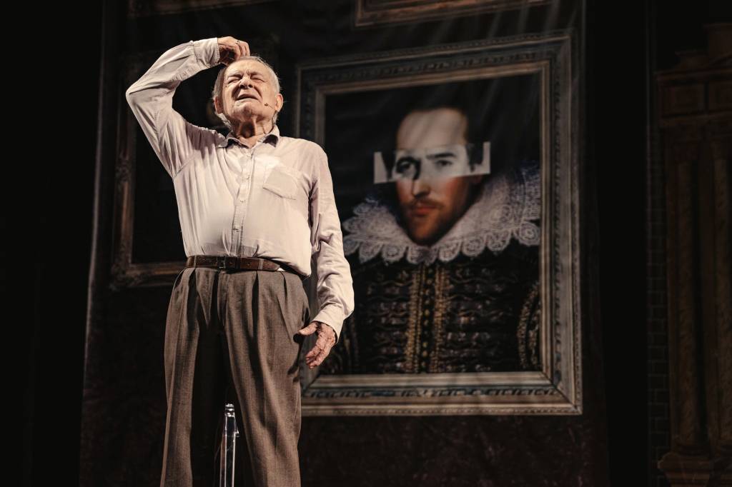 @jamesclickphoto 13112024 DSC01840.jpg Homem grisalho idoso de pé em palco de teatro com quadro atrás