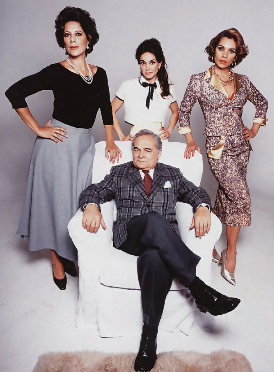 Ângela Vieira, Flávia Monteiro, Stella Maria Rodrigues e Othon Bastos, na peça t.jpg Homem grisalho senta em poltrona branca usando terno e de pernas cruzadas. Atrás, ao redor dele, estão três mulheres, uma de saia cinza e peça preta, a outra de branco e a terceira com saia e terninho de oncinha