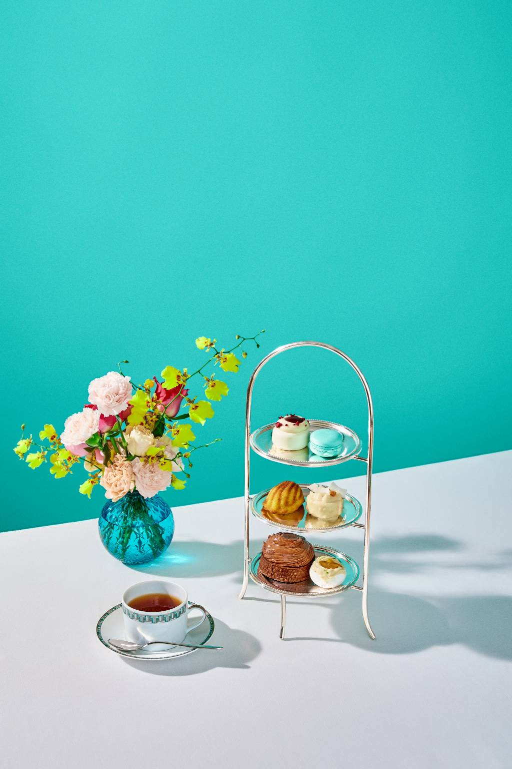 ElizaWar_Tiffany&Co._Cafe_0309 (2) Itens em cima de prateleira com fundo azul e vaso de flores