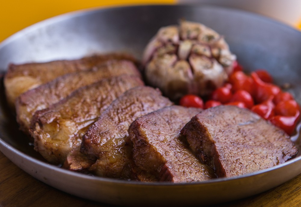 Carne no prato preto e fundo amarelo