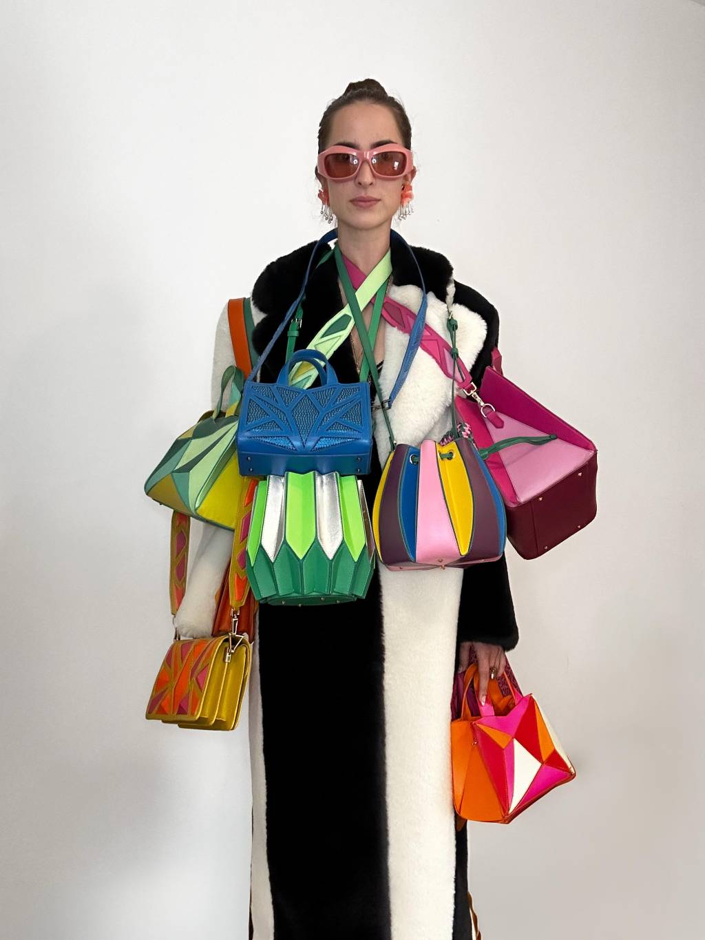 Luiza Mallmann Crédito Ryzí Studios-Divulgação Luiza Mallmann, da Ryzí, posa com óculos rosa e repleta de bolsas penduradas no corpo