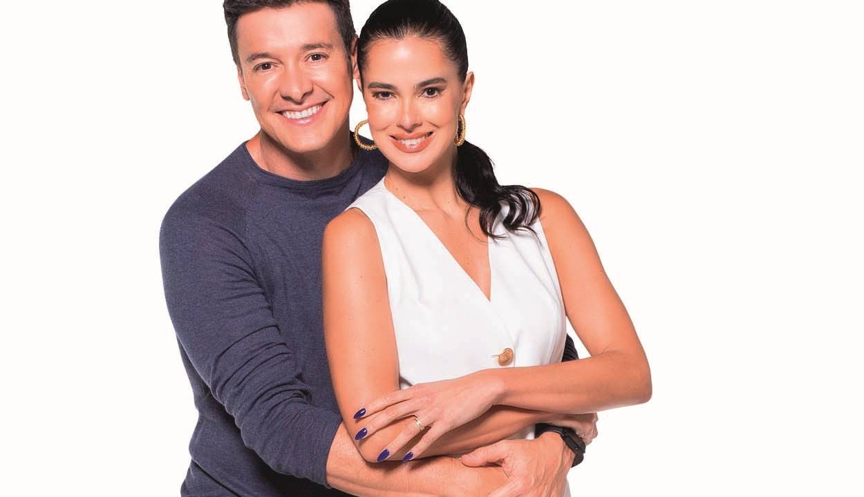 Rodrigo Faro e Vera Viel abraçados, com Rodrigo atrás dela segurando a cintura