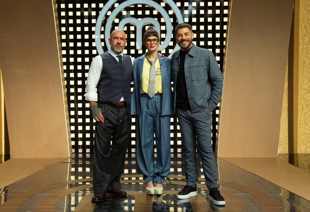 Alessandra Gerzoschkowitz_credito_003 No cenário do MasterChef, estão três pessoas de pé: Henrique Fogaça, Helena Rizzo e Evaristo Costa