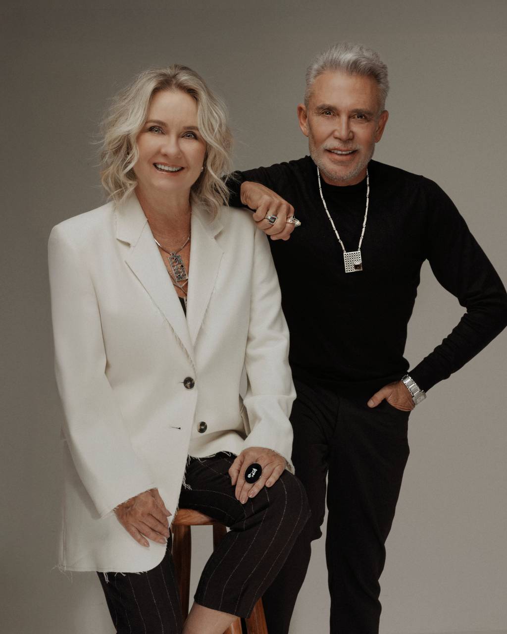Isabella Blanco e Léo Shehtman Crédito João Viegas-Divulgação Mulher loira de branco ao lado de homem grisalho de preto