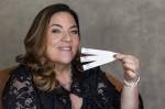 Renata Ashcar, mulher de cabelos lisos castanhos segurando papéis de perfume