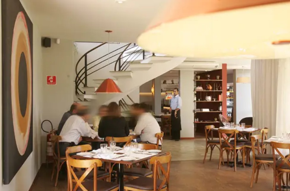 Ambiente com mesas e pessoas Casa Santo Antonio