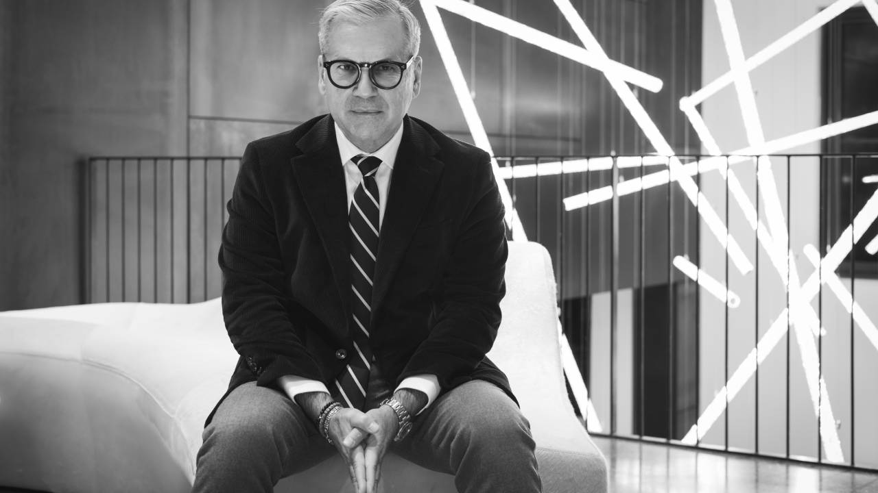 Alexis Nasard, CEO da Swarovski, sentado de terno e gravata em foto preto e branco