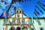Fachada da igreja vista de baixo com bandeiras coloridas