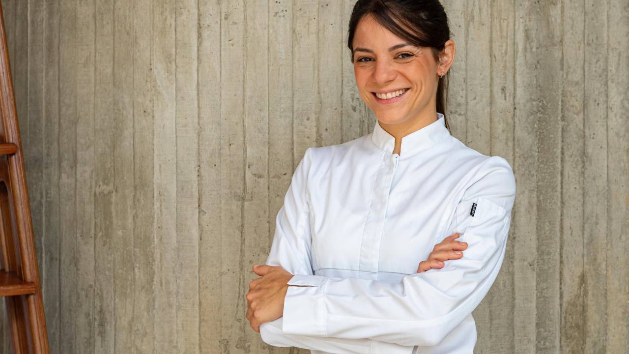 Elisa Fernandes veste branco de braços cruzados
