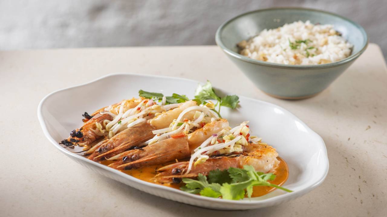 Prato branco com camarão e arroz atrás