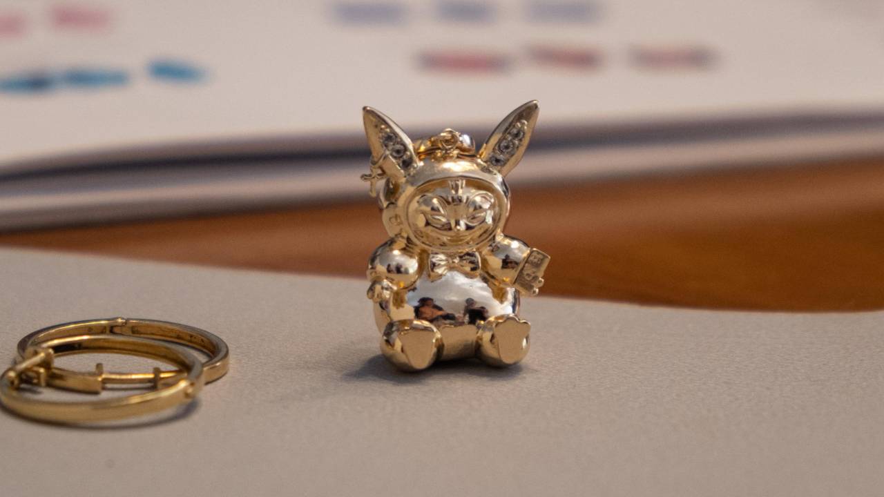 Linha Lakadu, collab de Kadu Dantas com K.Stockler. Foto exibe pingente dourado parecido com Pikachu