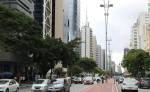 Avenida com carros e prédios e postes