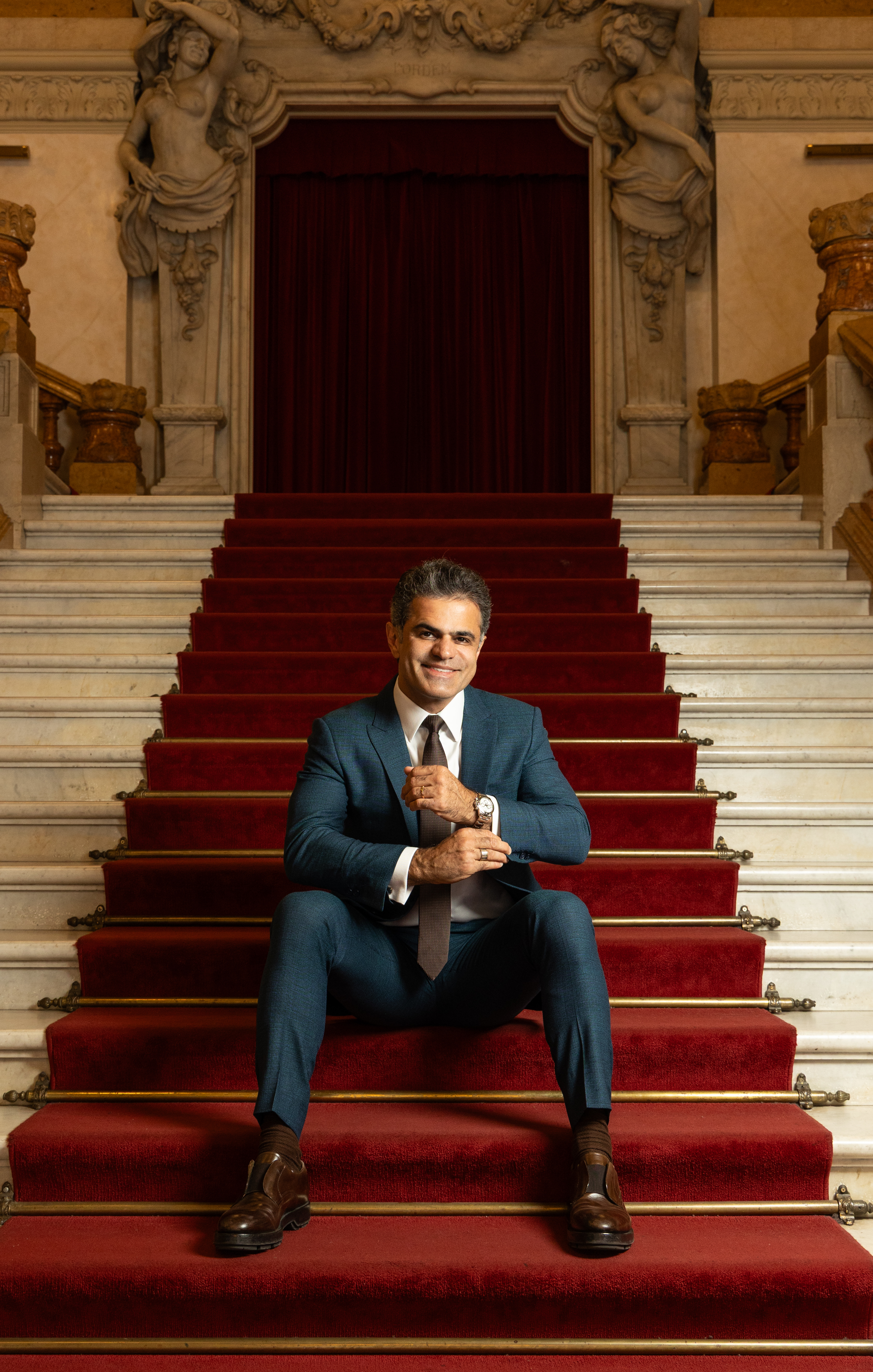 Alfaiate Jo&atilde;o Camargo sentado na escadaria do Theatro Municipal com tapete vermelho