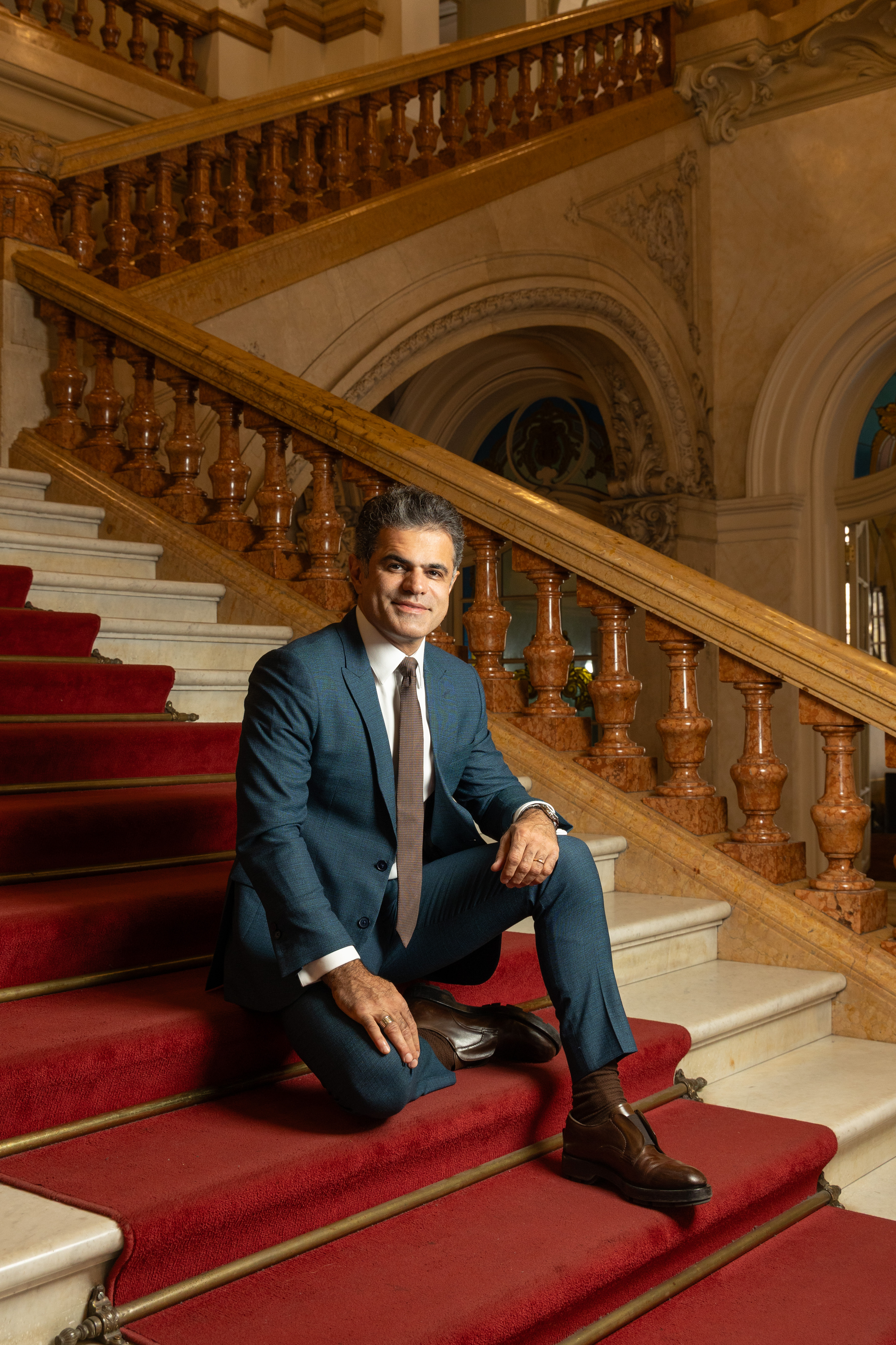 Alfaiate Jo&atilde;o Camargo sentado na escadaria do Theatro Municipal com tapete vermelho