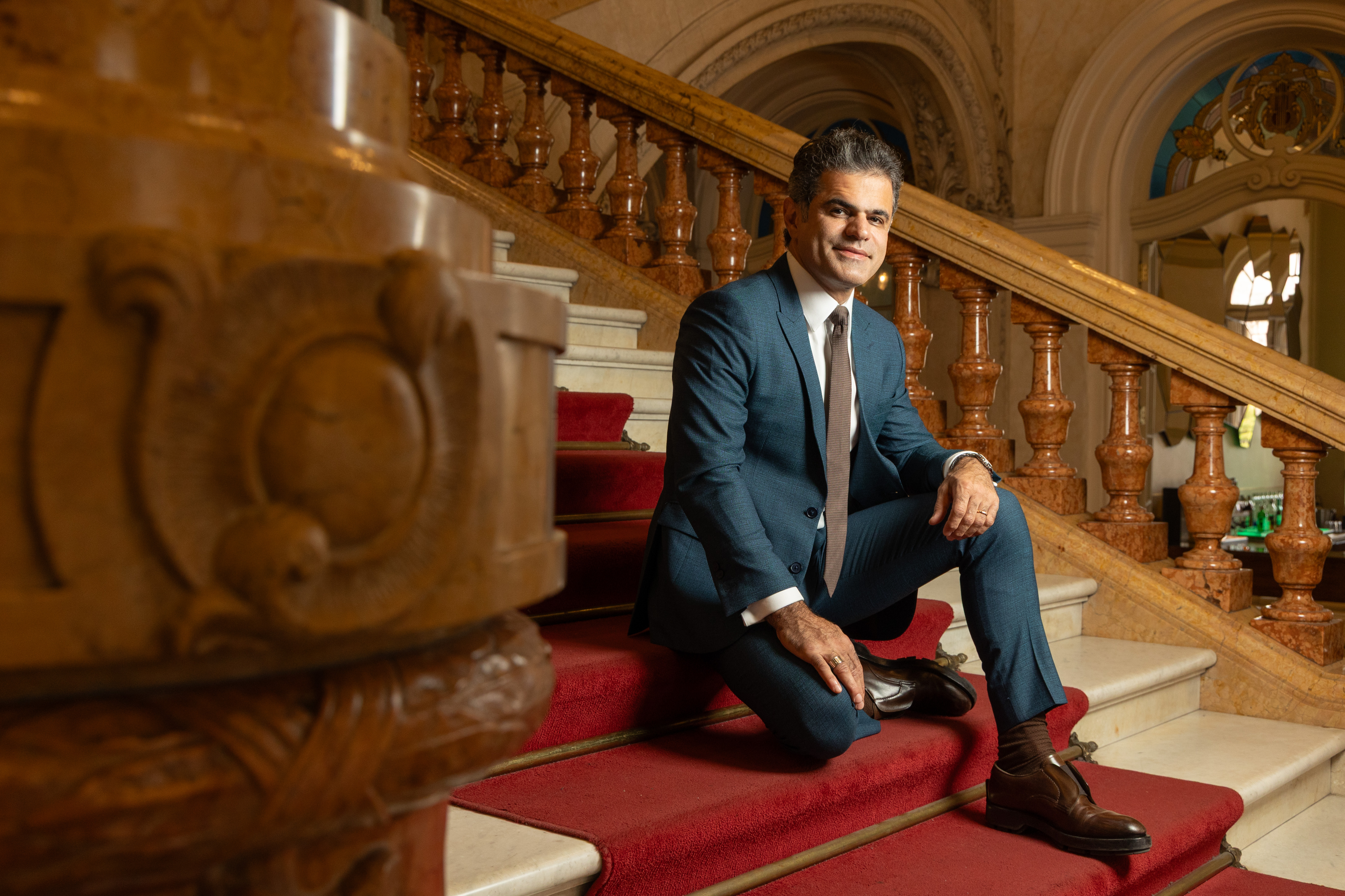 Alfaiate Jo&atilde;o Camargo sentado na escadaria do Theatro Municipal com tapete vermelho