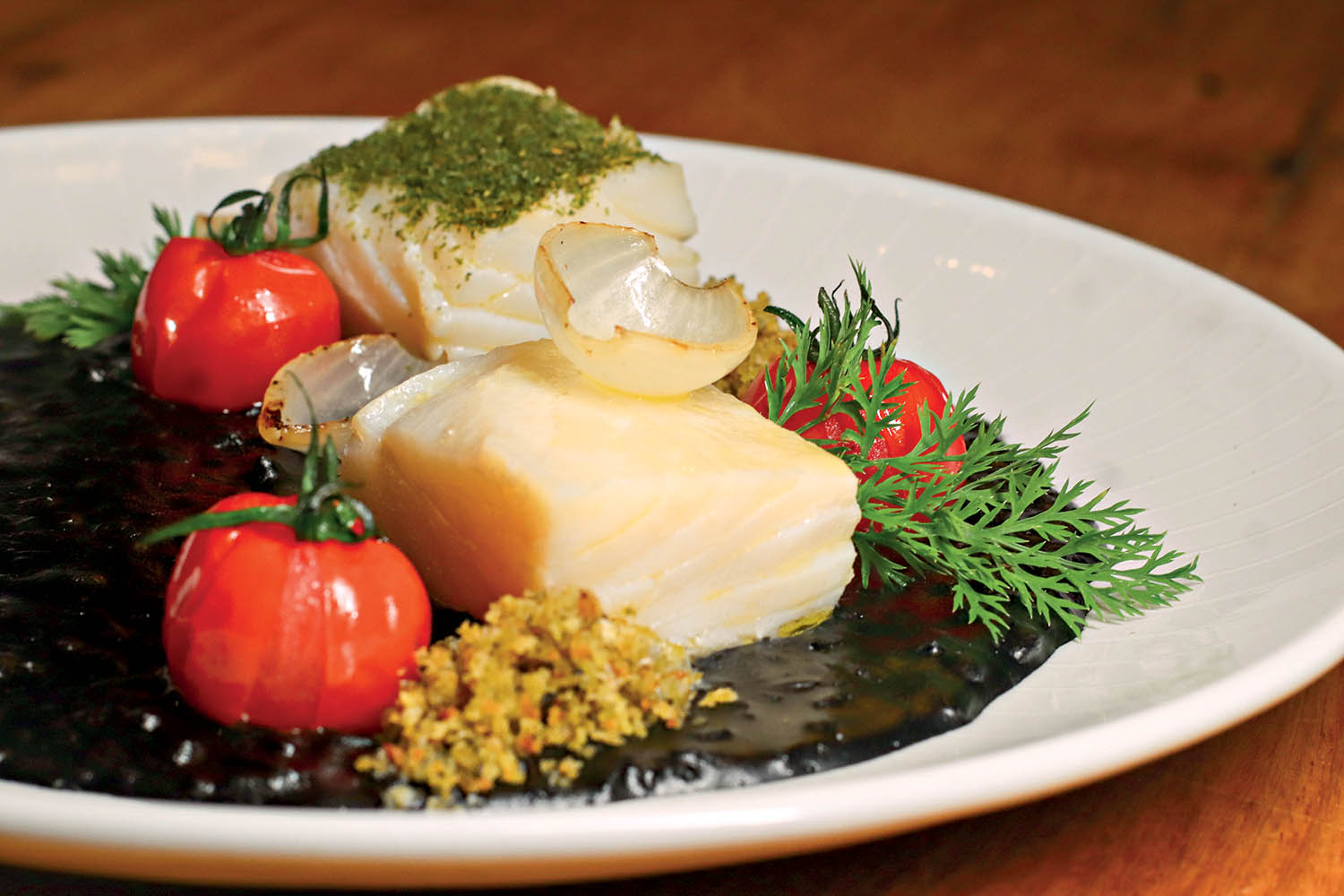 Bacalhau confitado com risoto de tinta de lula do restaurante Neto