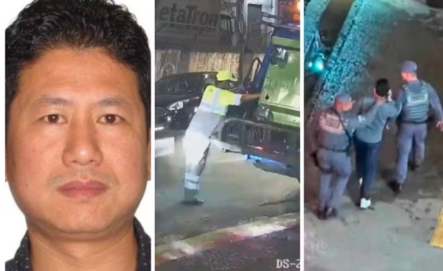 Homem asiático de meia-idade com cabelo escuro e camisa preta de bolinhas, ao lado de um guincho verde rebocando um carro preto e dois policiais militares conduzindo um homem em uma rua escura