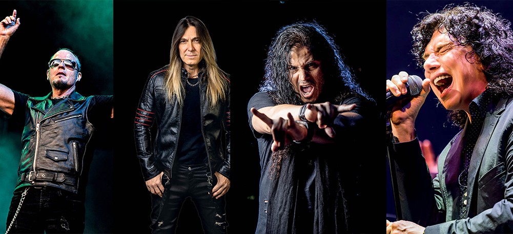 Quatro homens, músicos de rock, em poses de palco. Da esquerda para a direita: um homem de colete de couro e óculos escuros com o braço levantado; um homem de cabelo comprido e jaqueta de couro preta; um homem de cabelo comprido e camisa escura fazendo um gesto com as mãos; um homem de cabelo encaracolado cantando em um microfone com a boca aberta