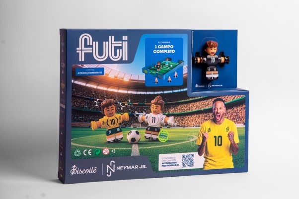 Caixa do brinquedo Futi, com o logo em azul e branco. A embalagem mostra bonecos de futebol em campo, um jogador de camisa amarela com o número 10, e um campo de futebol de mesa. No canto inferior direito, Neymar Jr. em camisa amarela com o número 10, comemorando