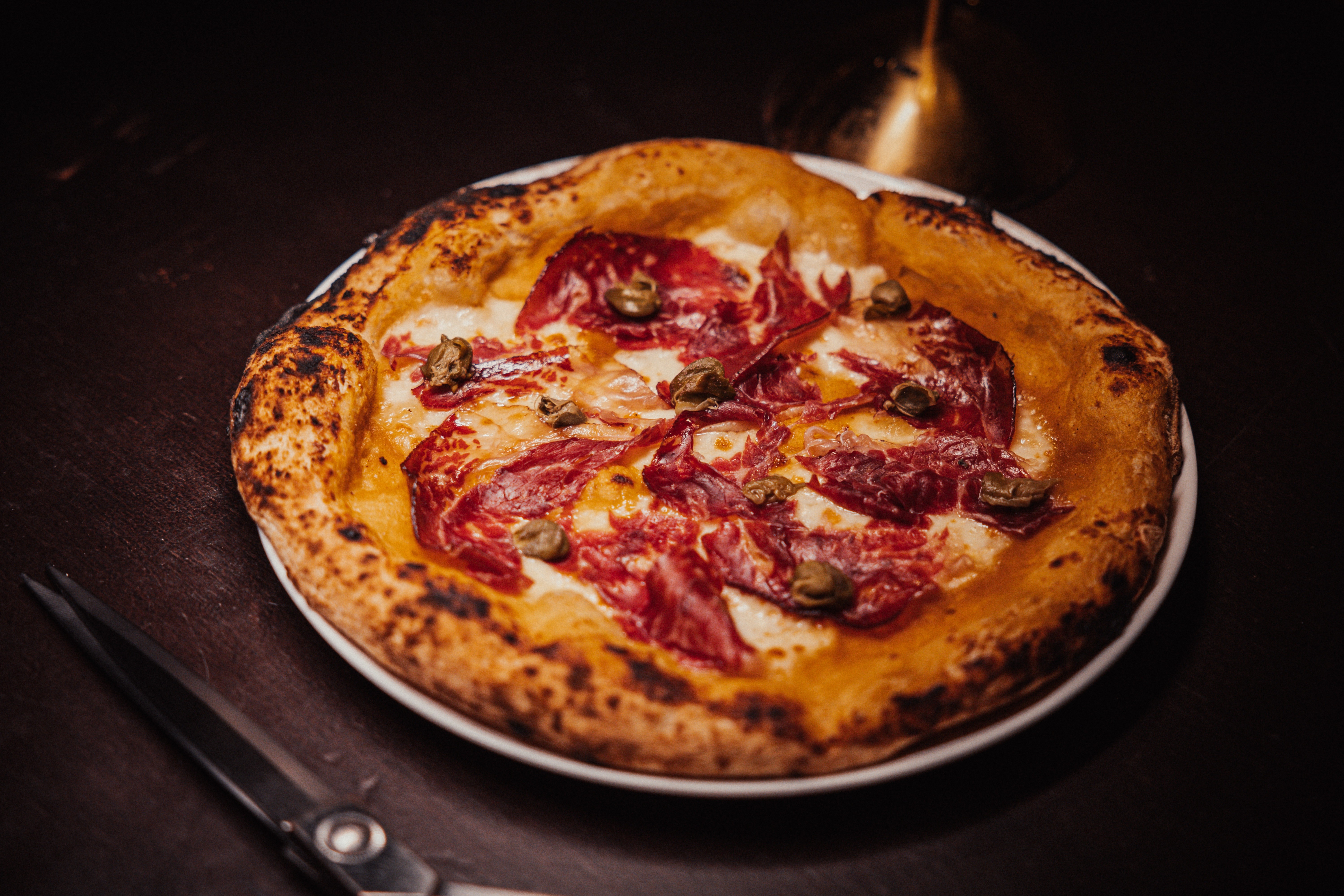 Pizza com cobertura de carne curada ao estilo espanhol de León